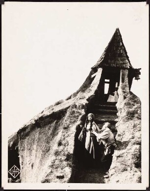 Filmarchitektur: Der Golem: Turm, Wächter, Der Torwächter übergibt der Tochter des Rabbi Löw ein Geschenk des Königsboten