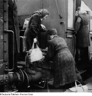 Leipzig. Hauptbahnhof. Überfüllter Personenzug ("Hamsterzug") mit Reisenden auf Puffern und Trittbrettern