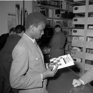Afrikanischer Polizeischüler beim Betrachten eines Buches. Aufnahme wohl in einer Bibliothek