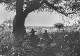 Expeditionsteilnehmer im hohen Gras : Expeditionsteilnehmer bei einer Pause im hohen Gras.