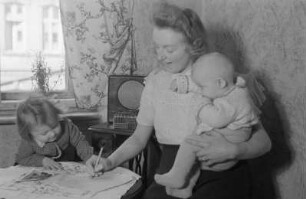 Reportage: Berliner Männer und Frauen tragen sich für die Ächtung der Atombomben ein : Mutter mit Kindern trägt sich in die Unterschriftenliste ein