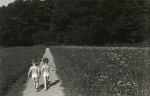 Zwei nackte Kinder, auf einem Wiesenweg laufend