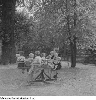 Kinder auf einem Karussell auf einem Spielplatz im im Clara-Zetkin-Park