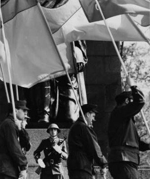 Soldat der Nationalen Volksarmee und fahnentragende Kampfgruppen am "Tag der Befreiung" am Sowjetischen Ehrenmal