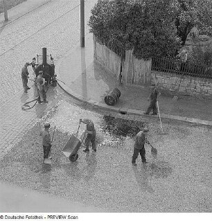 Dresden-Leutewitz. Straßenbauarbeiten Auf der Scheibe Ecke Warthaer Straße, Herstellen einer Einstreudecke (Splitt) auf bituminösen Bindemittel, aufgebracht mit Bitumenspritzmaschine