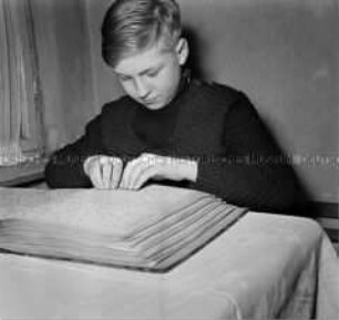 Junge beim Lesen von Blindenschrift
