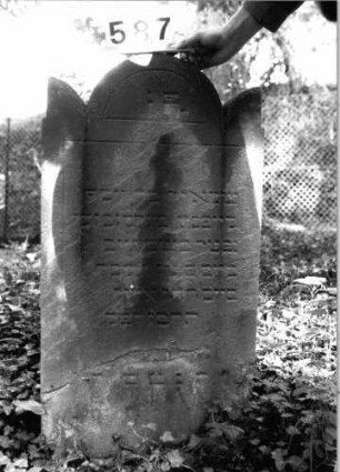Grabstein 587 (Index: 99802839) Material: Sandstein Zustand: stark verwittert/abgeblättert Maße HxBxT: 100x54x10 cm Beschreibung: Stele mit eingezogenem Rundbogen u8nd Seitenakroterien: Grabstein 587
