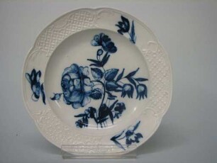 Flacher Teller mit profiliertem Rand und Blumenmalerei in Unterglasurblau