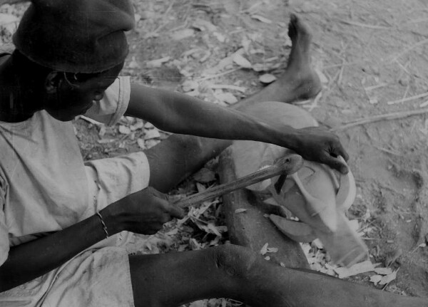 Mask carver at work with an adze