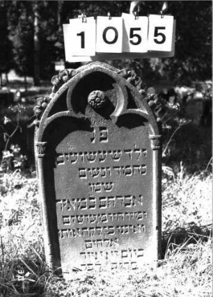 Grabstein 1055 (Index: 100098942) Maße HxBxT: 80x41x10 cm Symbolik: Blumenkranz Besonderheit: Kindergrab: Grabstein 1055