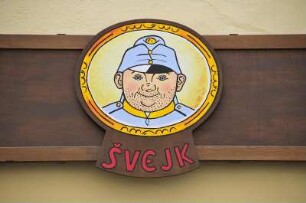 Swejk in Prag : U Fleku, Prags berühmtestes Bierlokal in der Neustadt, ist im neugotischen Stil eingerichtet. Wahrzeichen ist die große Bieruhr an der Aussenfassade. Bild: Bildnis des braven Soldaten Schwejk, aufgenommen 2008 in Prag