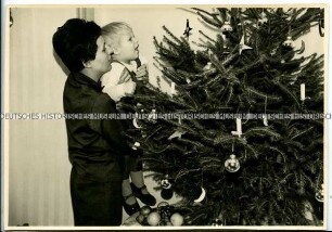 Mutter und Kind am Weihnachtsbaum