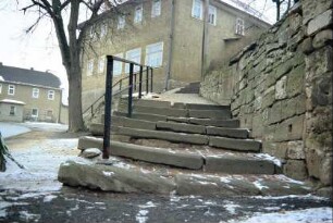 Naturstein-Treppe an einer Trockenmauer, führt zur Kirche
