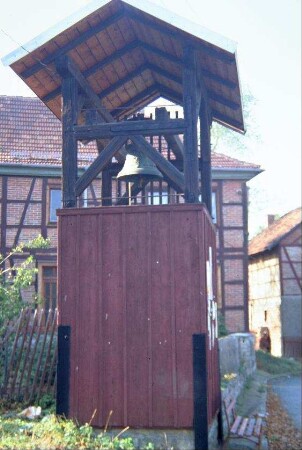 freistehender Glockenstuhl mit Überdachung und Holzumbau; Ort hat keine Kirche