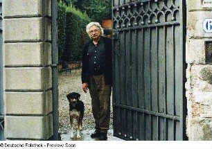 Der Maler Peter Herrmann mit Hund am Gartentor der Villa Romana