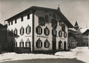 Oberammergau. Ein mit Lüftlmalerei verziertes Wohn- und Geschäftshaus in der Dorfstraße im Winter