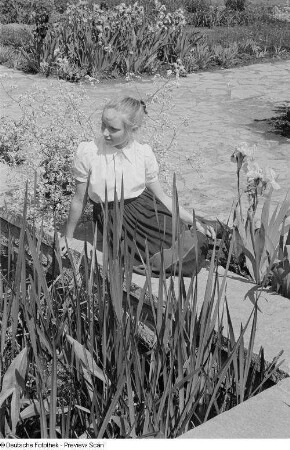 Mädchen, an einem Ufer sitzend