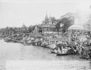Varanasi (Benares), Indien. Stadtteilansicht mit Tempelanlagen. Blick vom Ganges zum Ufer mit Gläubigen