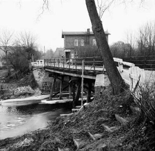 Trave: Holzbrücke in baufälligem Zustand: vorn rechts Baumstamm: dahinter Gaststätte "Brückenkrug" von August Behnk: Winter