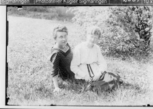 Zwei junge Frauen im Gras sitzend