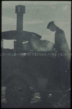 Soldat an einem Feldkochherd