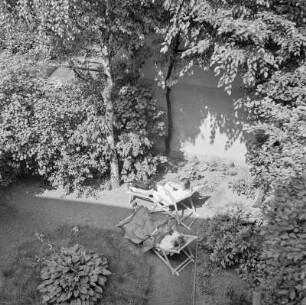 Blick in den Garten mit Frauen im Liegestuhl