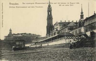 Elbwasserstand 1904. Sammlung von 26 Postkarten (im Schuber) mit Ansichten von der Elbe an der Augustusbrücke in Dresden, verfertigt anläßlich des niedrigen Wasserstandes im Sommer 1904. Blick vom ausgetrockneten Flußbett am Ufer vor Helbigs Etablissement mit Pavillon der Bootsanlegestelle gegen die Türme von Frauenkirche, Hofkirche und Schloß sowie das Ständehaus im Bau. Druck nach Fotografie (Weltpostkarte); 8,9 x 13,9 cm. Dresden: SLUB Hist.Sax.G.695