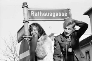 Freiburg: Rosenmontagsumzug [zwei Zuschauer am Straßenschild]