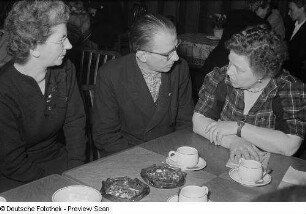 Zwei Frauen und ein Mann beim Kaffeetrinken