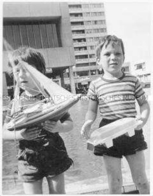 Zwei kleine Jungen mit Spielzeugschiffen (Altersgruppe bis 14)