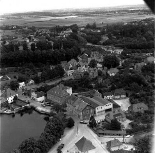 Claudius-Mühle (Matthias-Claudius-Straße 3): Luftbild des Betriebs: im Vordergrund links Herrenteich, im Hintergrund Matthias-Claudius-Kirche mit Kirchhof, rechts Neuhofer Teich