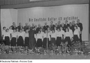 Chor und Chorleiter des VEB Eilenburger Celluloid-Werk beim Bezirksausscheid der Volkskunstgruppen 1954