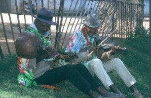 Madagaskar, Ambohimahasoa. Zwei Straßenmusikanten mit Jejy voatavo (Stabzither) und Geige