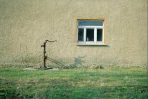 Wasserpumpe vor einem Haus