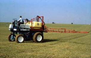 Fotografie: Weinbau, Traktor, Trägerfahrzeug, Pflanzenschutz, Feldspritze angebaut, Getreide