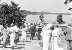 Berlin: Freibad Wannsee; Badegäste kommen (mehr Leute, Hintergrund See)
