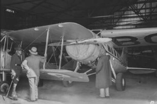 Flugzeuge : Blick in ein Flugzeughanger mit Flugzeugen und Personen