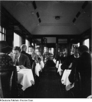 Mitropa-Speisewagen. Blick in Längsrichtung Mittelgang auf Plätze mit Reisenden : Deutsche Reichsbahn. Mitropa-Speisewagen. Blick in Längsrichtung Mittelgang auf Plätze mit Reisenden