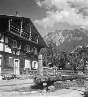 Wohnhaus gegen Gebirge (wahrscheinlich im Allgäu)