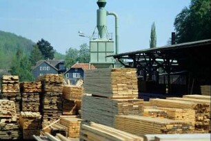 Sägewerk am Ortsausgang, große Stapel geschnittener Bretter