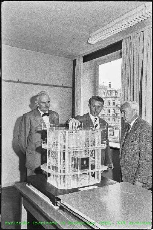 Drei Personen bei der Betrachtung eines Modells des Forschungsreaktors 2 (FR 2)