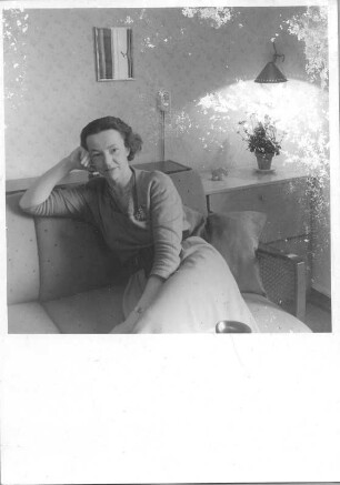 Porträt einer Frau, auf einem Sofa sitzend