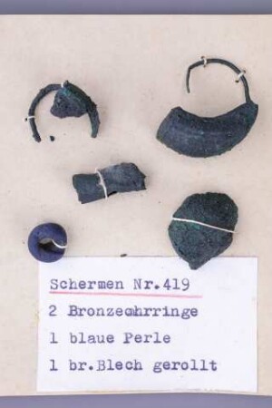 Segelohrringe und eine blaue Glasperle