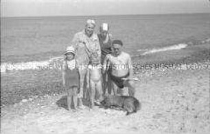 Familie, zwei Erwachsene, drei Kinder und ein Hund am Strand von Köslin