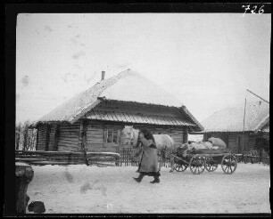 Judogalwi (=Juodagalviai, Litauen): Einheimische mit Einspänner und Pferdewagen auf schneebedecktem Weg vor einem reetgedeckten Holzhaus ("Bauernfuhrwerk")