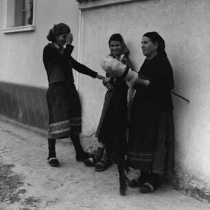 Drei Frauen im Gespräch vor einem Wohnhaus in Razhevo Konare. Die alte Handwerkskunst des Spinnens wird ausgeübt