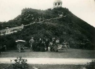 Hongkong. Gruppenbildnis mit Touristen vor dem Victoria Peak, darunter eine Dame in einer Sänfte