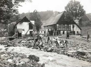 Unwetterkatastrophe im Osterzgebirge am 8./9. Juli 1927. Zerstörte ältere Bauernhäuser in Schönwald (heute Petrovice-Krásny Les). Ansicht mit beginnenden Aufräumarbeiten