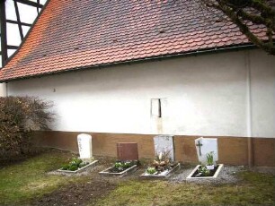 Kirchhof im Norden-Kirchhofmauer als Außenwand eines ortsseitig im 18 Jh nach Abtragung des Wehrgangs angebauten Gebäudes-Schlitzfenster zur Temperaturregulierung (Außengaden)