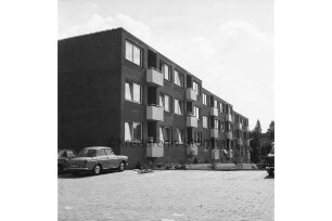 Wolkenweher Weg: Wohnblock der Gemeinnützigen Wohnstättengenossenschaft eG Bad Oldesloe: davor Grünanlage und Parkplatz mit Pkws